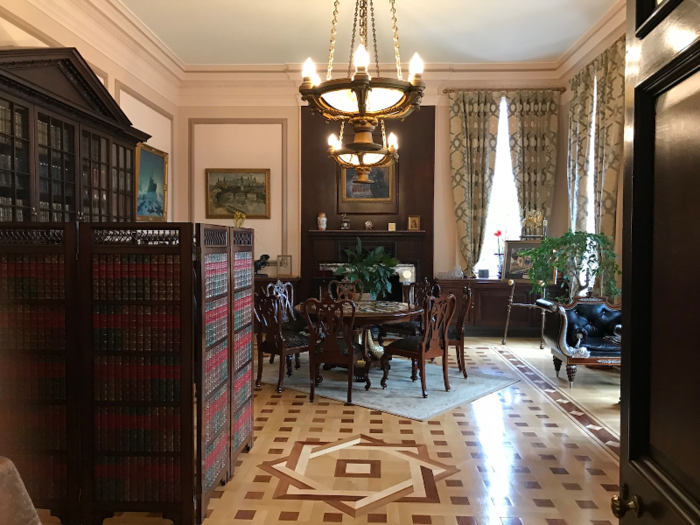 As we stroll around, two Russian aides standing nearby suggest that we leave our things in their cloakroom. The makeshift cloakroom is in a salon, with our coats kept behind a divider trying to look like bookcases. Another Russian-speaking worker takes our coats.