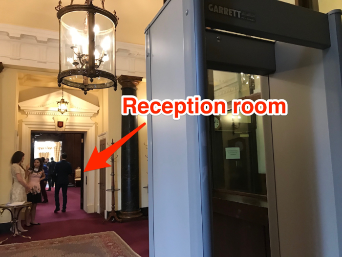 The foyer leads into a grand, red-carpeted reception room.