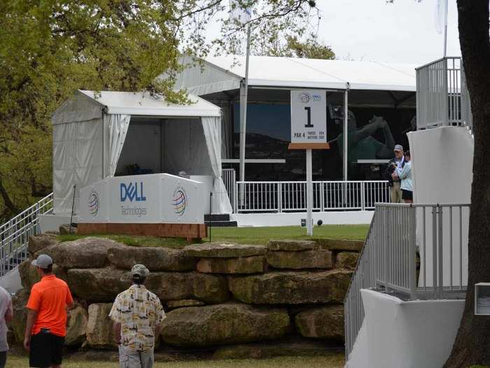 For those not sitting in the seats or standing along the fairway, a crowd gathers here to look up at the golfers as they start their round.