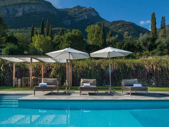 A pool in the back yard is surrounded by mountains and the lake.