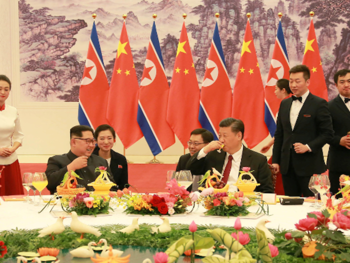 The North Korean and Chinese leaders, and their wives, seemed to enjoy themselves. Here they are apparently laughing at something Kim said. Their aides, potentially translators, seated behind the dinner guests, are also smiling.