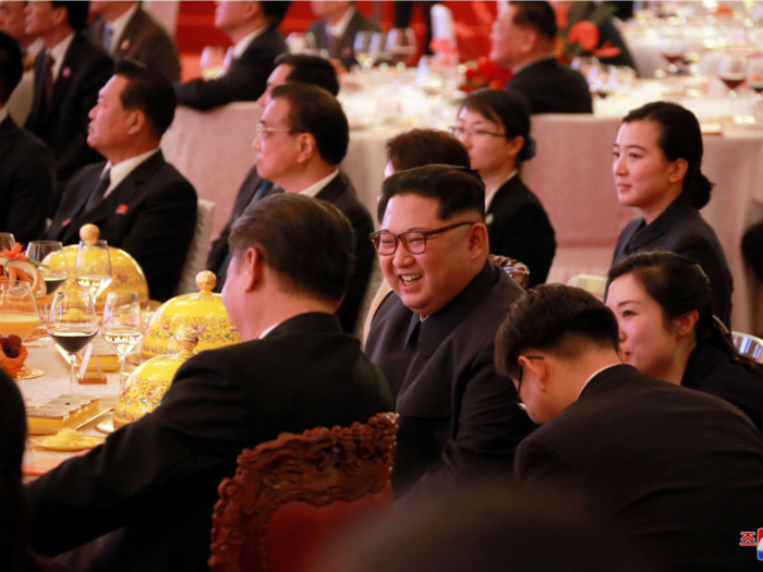 Other courses were covered with a yellow cloche with a golden handle. Kim appears to be drinking orange juice along with his wine.