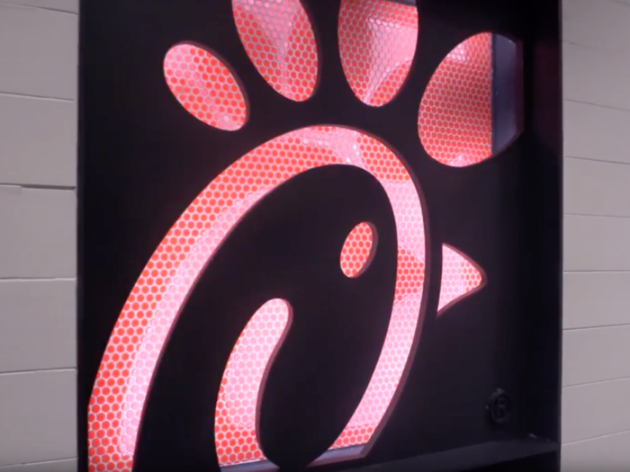 Walking into the restaurant, customers are greeted by the neon Chick-fil-A logo.