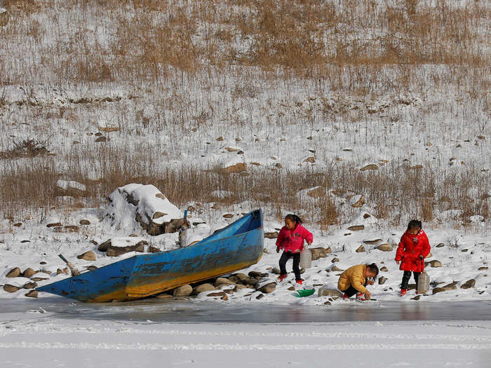 The isolation on the North Korean side of the border was broken only occasionally. "Driving along those frozen fields, past villages with rickety houses or small, dirty industrial towns, I only rarely saw people actually interacting with each other," Sagolj said, "once two women fighting, the other time, three beautiful little girls in new red boots playing while they fetched the water."