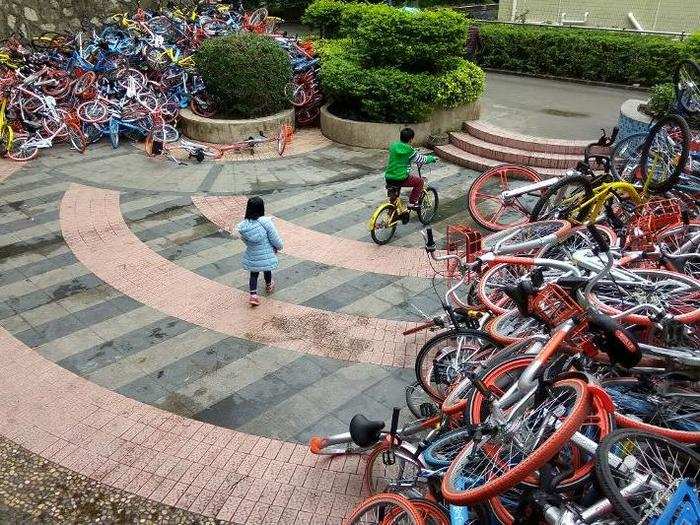 Since the bikes can be dropped off anywhere, riders sometimes leave them in front yards, parks, shops, and other inconvenient place. The photo below shows a pile of bikes some 10 feet high in a Shenzhen plaza.