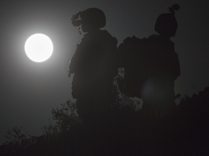 Capt. David Hirt, left, and Maj. Stephen Piantarnida observe the terrain using night-vision goggles during an air support exercise as part of a weapons and tactics course for instructors at Chocolate Mountain Aerial Gunnery Range, Arizona.