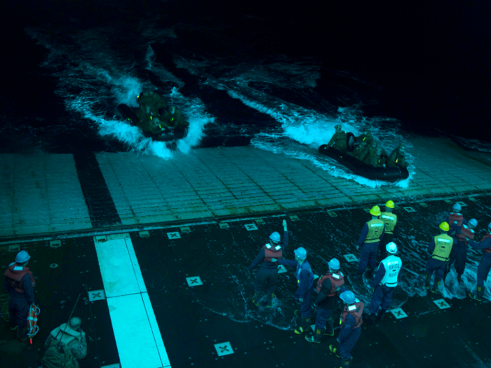 Sailors recover combat rubber raiding craft with Marines assigned to the 31st Marine Expeditionary Unit (31st MEU) during night operations in the well deck of the forward-deployed amphibious assault ship USS Bonhomme Richard.