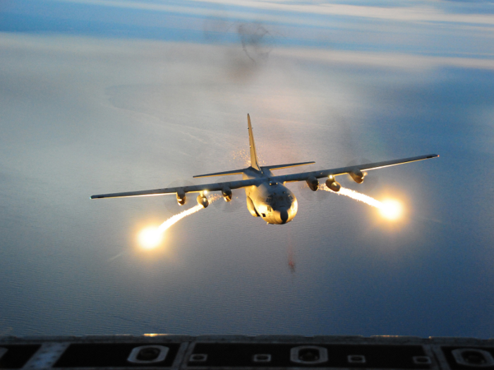 A US Air Force C-130 Hercules cargo aircraft with the 107th Airlift Wing fires off flares during a night formation training mission.