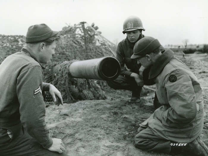 Cpl. Jesse Cooper, Pyle, and Pvt. Willian Bennet at the muzzle of a 155mm gun in Anzio Beachhead area, Italy, on March 18, 1944.