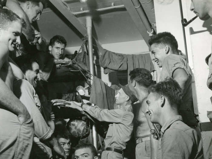 Pyle visiting with Marines aboard USS Charles Carroll while en route to Okinawa on March 20, 1945.