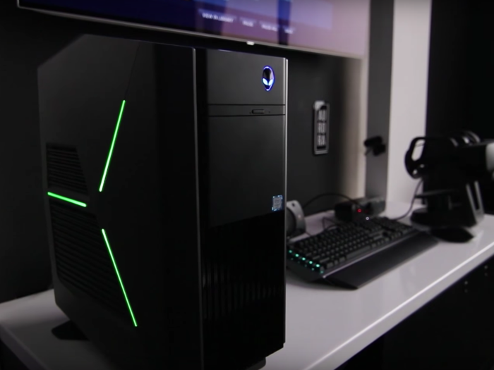 A close up of the battle station shows an Alienware Aurora desktop, a high-end gaming PC that starts at $899.99, and a color-changing backlit gaming keyboard, complimented with two Xbox controllers and an Oculus Rift VR headset.