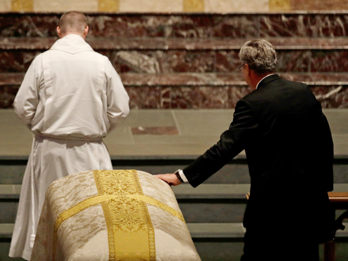 ... And placing his hand upon the casket.