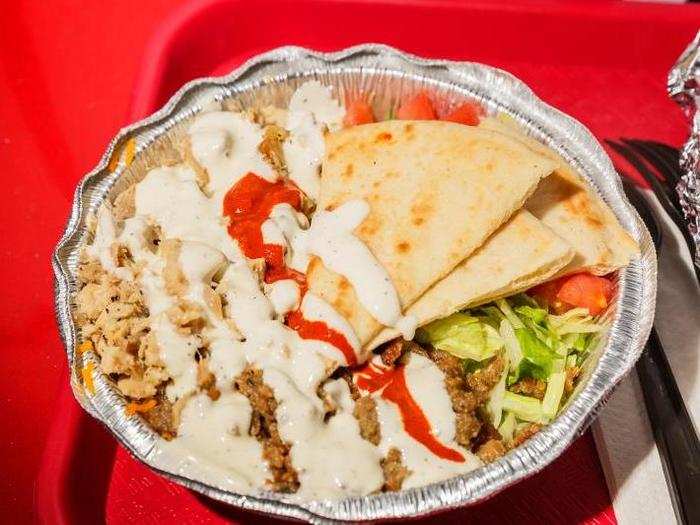 The platter consists of the meat of your choice — in this case, beef and chicken — with a generous heap of yellow rice, lettuce, tomatoes, some pita slices, and white and red sauce if requested. This is the small size — and it