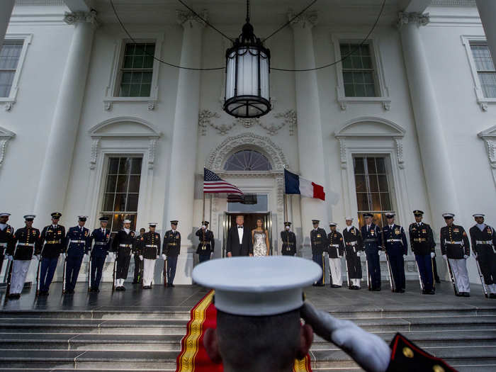 President Donald Trump and First Lady Melania Trump prepare to greet French President Emmanuel Macron and his wife Brigitte Macron as they arrive at the White House.