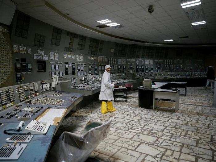 An employee walks inside the original control center of the third reactor at the Chernobyl nuclear power plant.