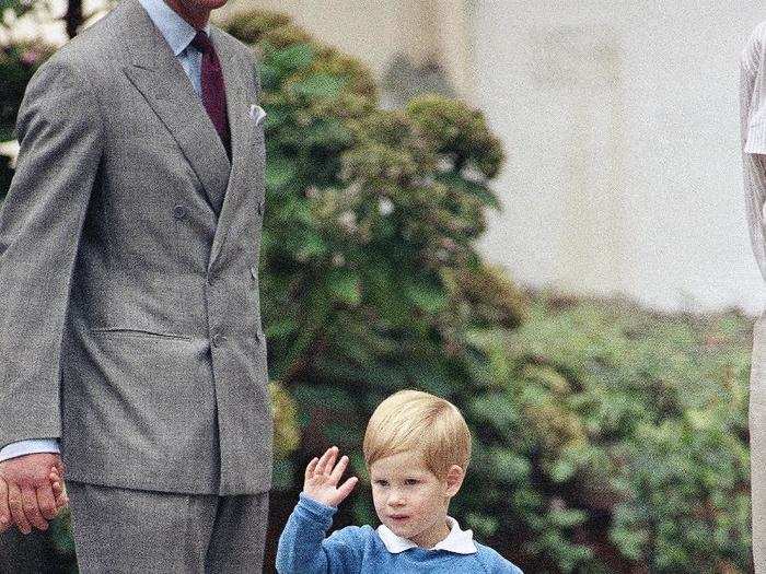 AGE 3: Prince Harry waves to photographers on his first day at a nursery school in Notting Hill on September 16, 1987.