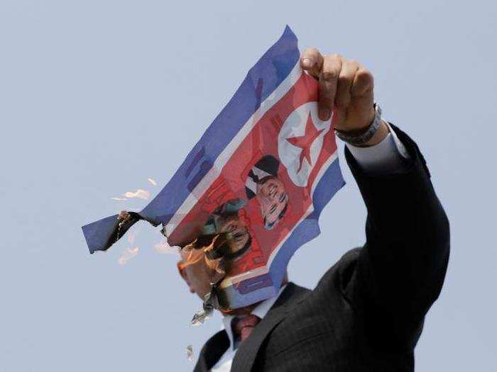 But not everyone supported the talks between Kim and Moon. Here, a man burns a North Korean flag with photos of Kim and the late leaders, Kim Jong Il and Kim Il Sung.