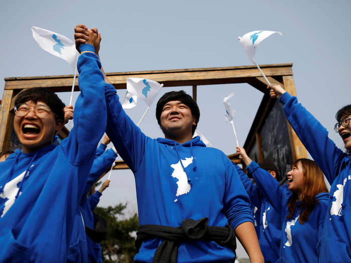 People wave the Korean unification flag during the inter-Korean summit, near the demilitarized zone in Paju, South Korea, April 27, 2018.