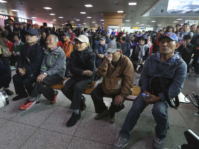 A South Korean man, second from right, wipes tears as people watch a TV screen showing the live broadcast of the summit at the Seoul Railway Station in Seoul, South Korea, April 27, 2018.