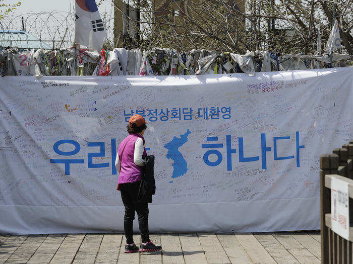 A visitor looks at a banner that says "We are one" at the Imjingak Pavilion in Paju, South Korea, April 28, 2018.