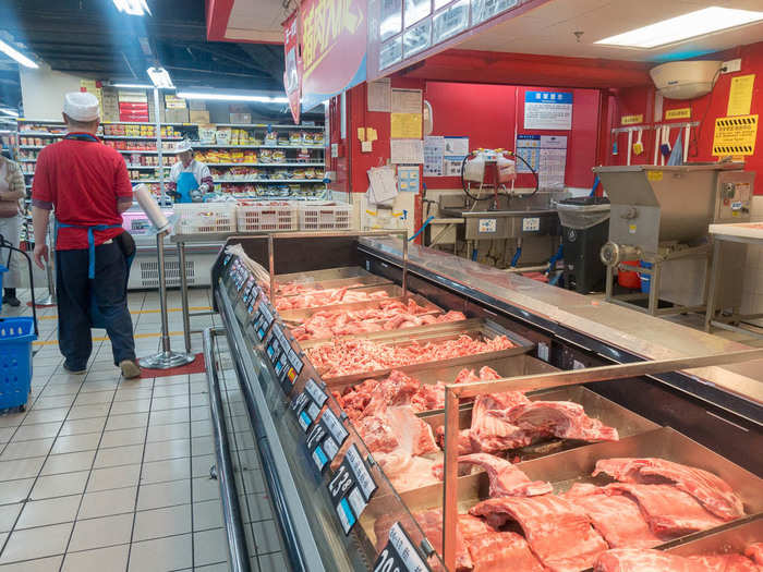 As well as various cuts of pig, including leg, ribs, and trotters. Behind the counter was a butcher