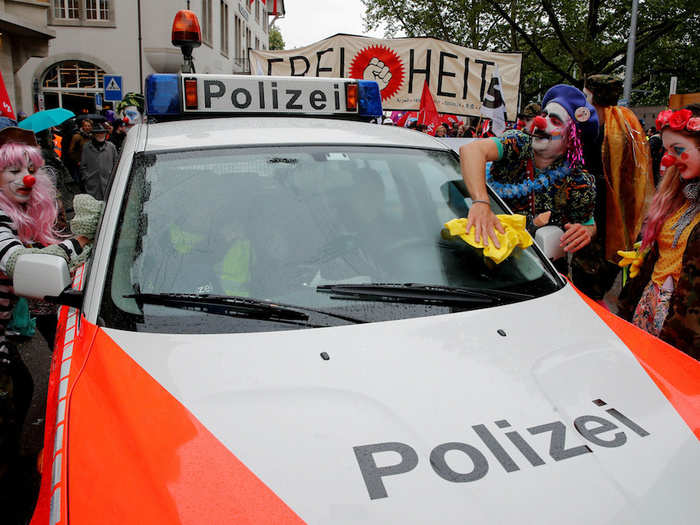 In Switzerland, the day was marked by more playful protests, as clowns wiped down a Swiss police car in Zurich.