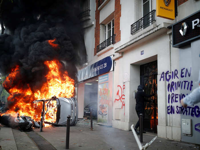 Hooded and masked anarchists were in the Parisian streets too, smashing windows, throwing cobblestones, and lighting cars on fire.