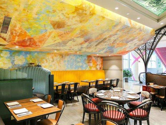 The walls and ceilings feature gorgeous custom murals and colorful seating.