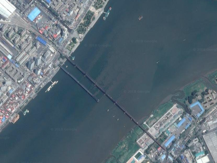 This satellite image shows the complete bridge and the broken one from above.