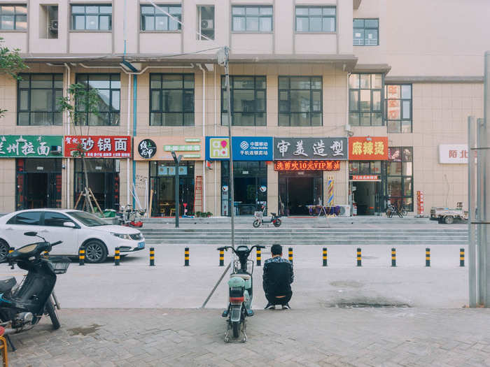 Like the makeshift restaurant district just outside the factory gates, the complex moves to the rhythms of the factory. When we walked in around 3 p.m., the area was deserted. Most of the shops were closed. Business owners were sleeping in the backs of their cars, taking a break before the factory let out in a few hours.