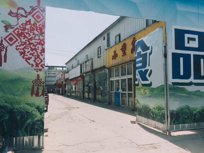 Just outside the entrance gate is a makeshift district of low-slung storefronts to serve factory workers who don