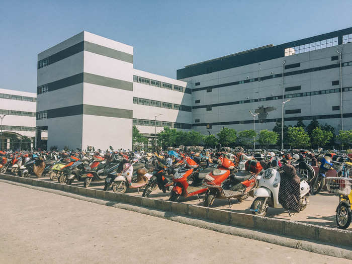 Workers on the day shift begin streaming in through the factory