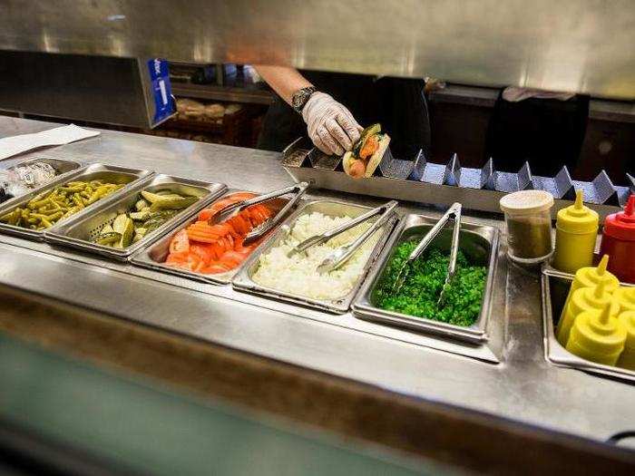 The "seven holy condiments" as Dolinsky calls them are: yellow mustard, neon-green relish, sliced tomatoes, chopped white onions, a pickle spear, sport peppers, and a shake of celery salt. To make it a Chicago dog, these toppings along with an all-beef dog, must be served in a steamed poppy seed bun.