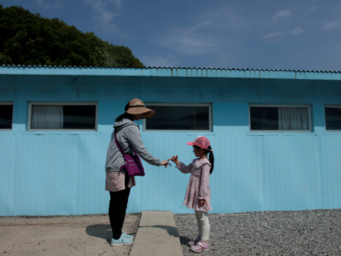 This woman and young girl engaged in their own version of the handshake, which seemed to involve their pinky fingers.