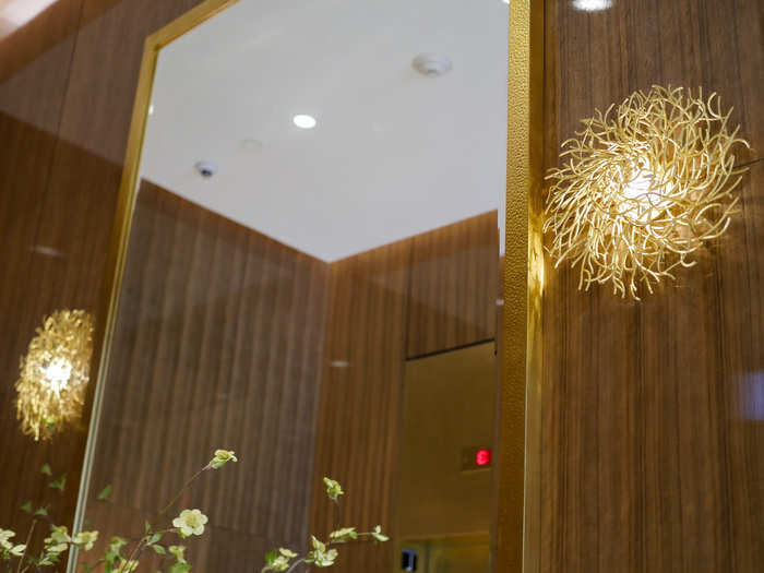 Mirrors and wall hangings in the lobby and throughout the building are cast in, you guessed it, more gold. These Orlando Diaz-Azcuy-designed gold sconces were crafted through various steps: each piece of the nest-like ornament was sculpted, hand-painted and laden with sand for an extra texture before being set in place.