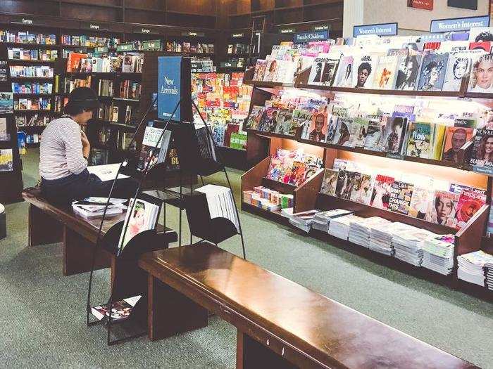 In the neighboring magazine section, people were sitting on the benches, flipping through stacks of magazines.