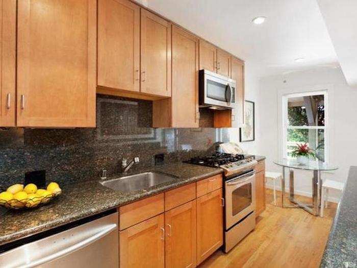 Similarly, the kitchen has granite countertops with stainless steel appliances and wood cabinets.