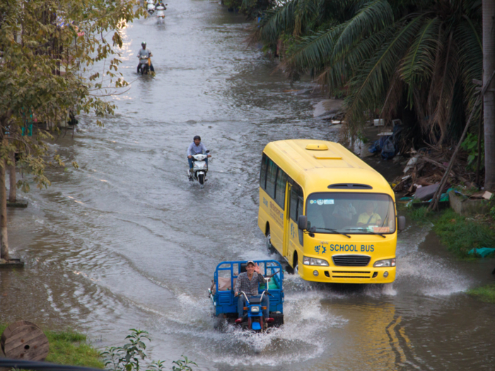 The buses in Vietnam need to navigate flooded roads during the rainy season. Fewer and fewer students are riding to school as the country