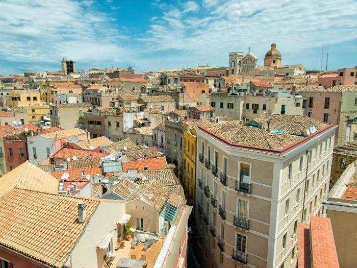 Admire the sun-drenched domes and rooftops of the old town over sundowners in Cagliari, Sardinia.