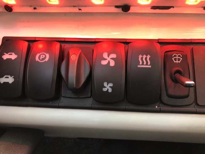 A row of switches and toggles controls the basic vehicle functions, including the parking brake and the transmission, as well as a heated seat.