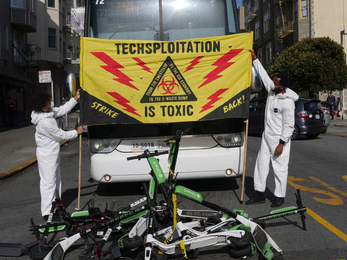 Activists piled scooters in front of buses and unfurled signs that read "Techsploitation is toxic."