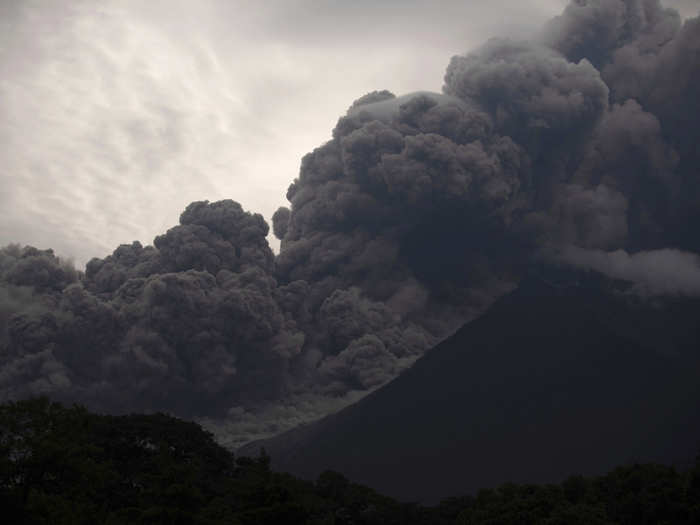 The volcano spewed ash miles into the sky and sent lava racing down the mountain slopes into neighboring villages.