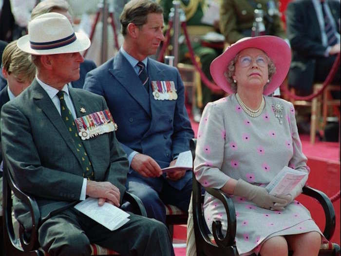 1995: Queen Elizabeth II looks up toward the sky as Prince Philip, left, and Prince Charles look on during memorial services to mark the 50th anniversary of VJ Day in London on August 19.