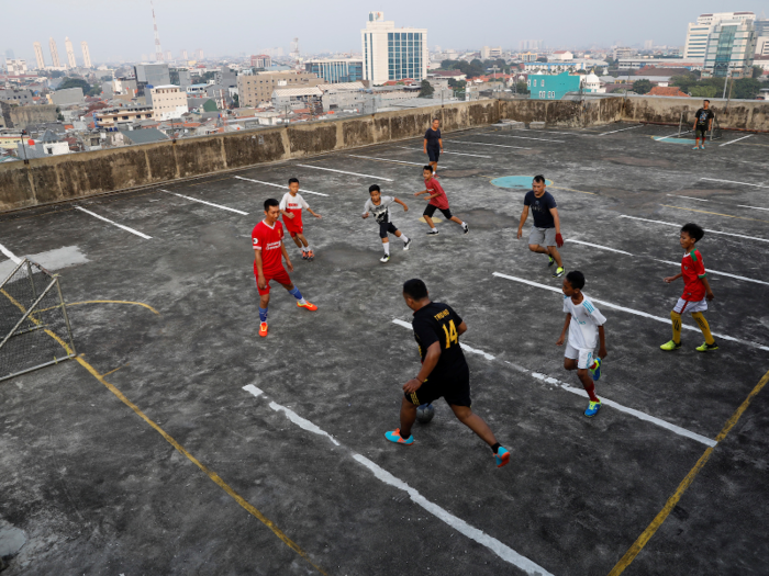 Soccer players can turn anything into a field, like this roof of a parking garage in Jakarta, Indonesia …