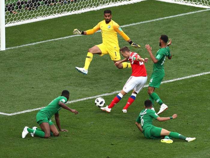 Denis Cheryshev of Russia scores as several Saudi Arabian players look on.