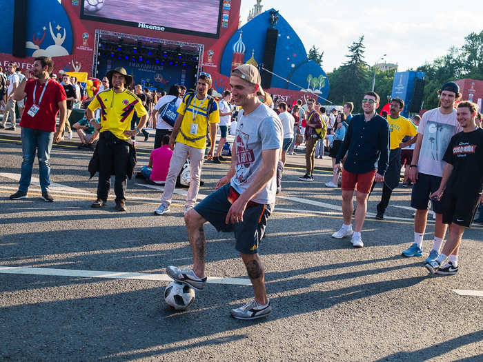 A ton of fans were gathered in a circle testing our their football skills. Each person took turns trying to dribble it past another person in the circle who acted as a defenseman.