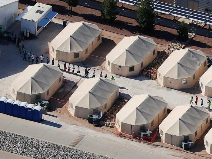 Aerial photos show kids walking through the newly formed tent city. Protesters gathered outside the facility on Sunday, calling for an end to the policy that separates the children from their families.