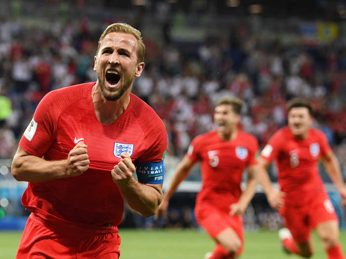 English captain Harry Kane holds out his jersey with pride after sending a stoppage-time header into the back of the net to salvage a 2-1 win over Tunisia.