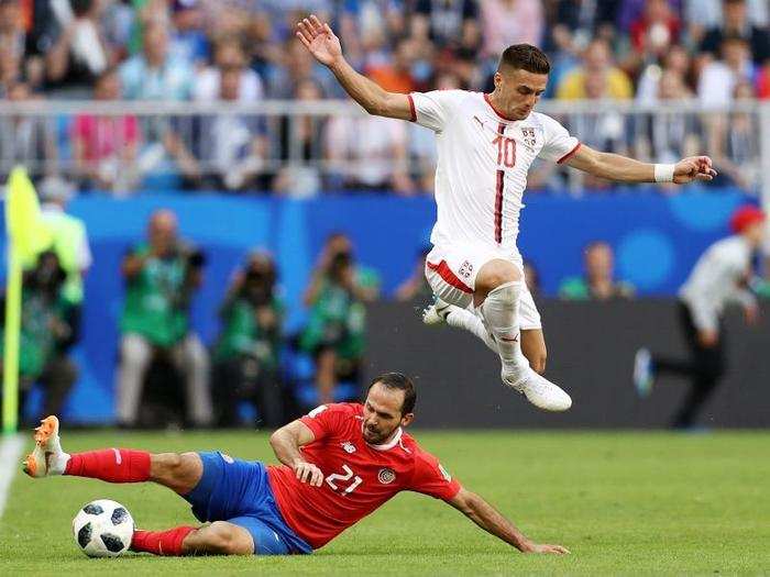 Marco Ureña of Costa Rica slides in to steal possession from Serbia
