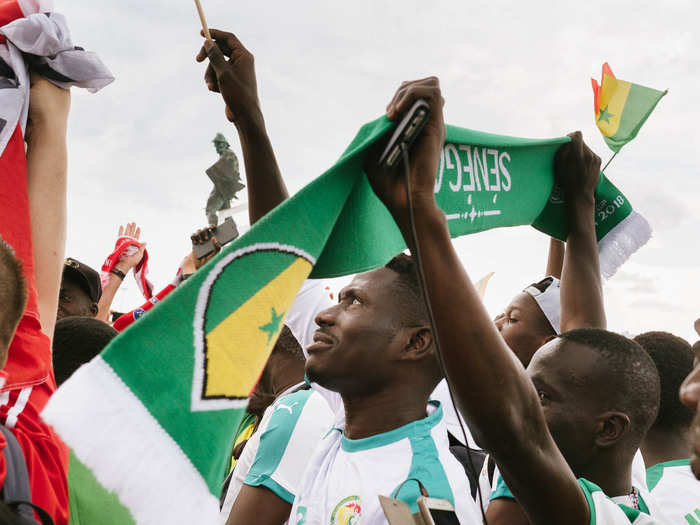 A group of Senegal fans were gathered in the grass, singing songs and waving Senegal flags. Their energy was contagious.